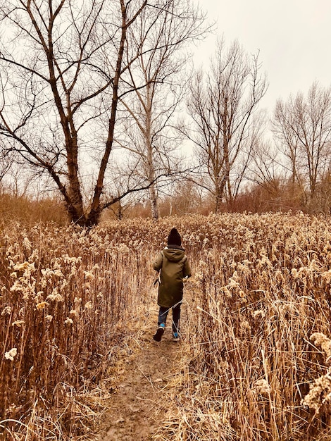 Foto vista traseira de uma mulher caminhando no campo