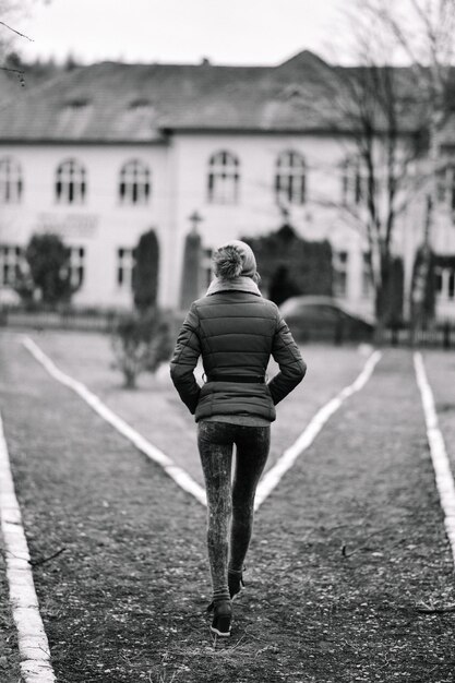 Foto vista traseira de uma mulher caminhando no campo