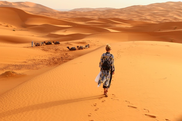 Vista traseira de uma mulher caminhando no deserto
