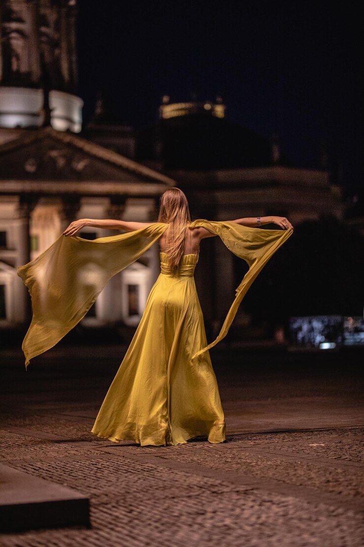 Foto vista traseira de uma mulher com os braços estendidos de pé na rua à noite
