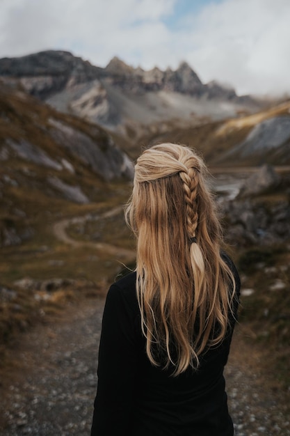 Foto vista traseira de uma mulher de pé contra a montanha