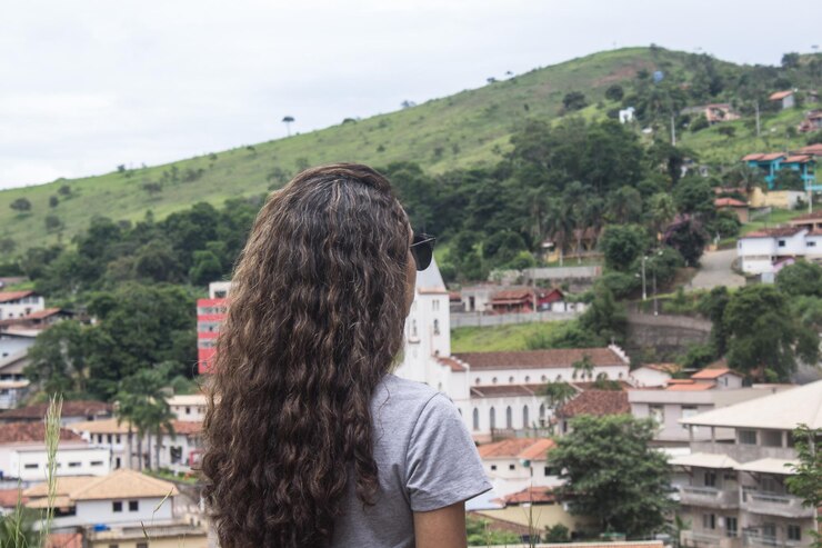 Foto vista traseira de uma mulher de pé contra a paisagem da cidade