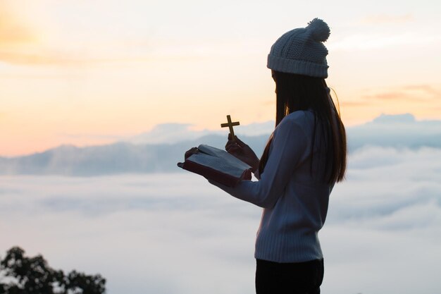 Vista traseira de uma mulher de pé contra o céu durante o pôr do sol