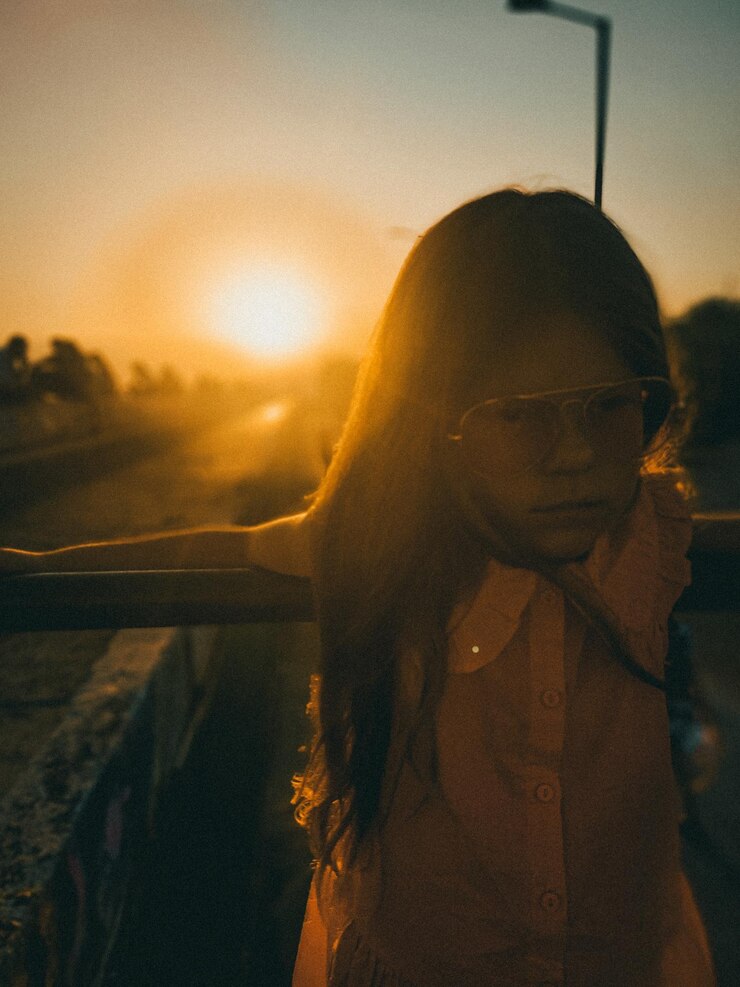 Foto vista traseira de uma mulher de pé contra o céu durante o pôr do sol