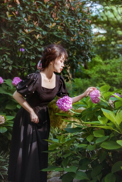 Foto vista traseira de uma mulher de pé junto a plantas