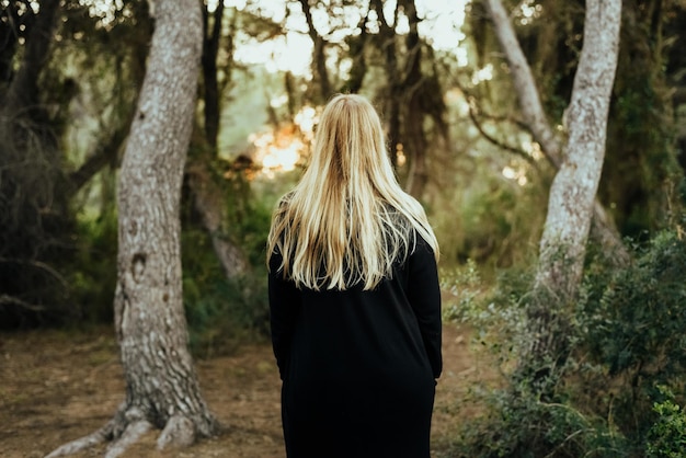 Foto vista traseira de uma mulher de pé na floresta