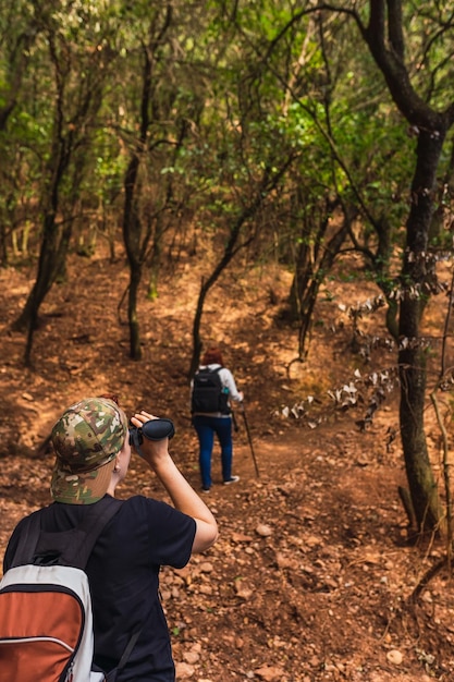 Foto vista traseira de uma mulher de pé na floresta