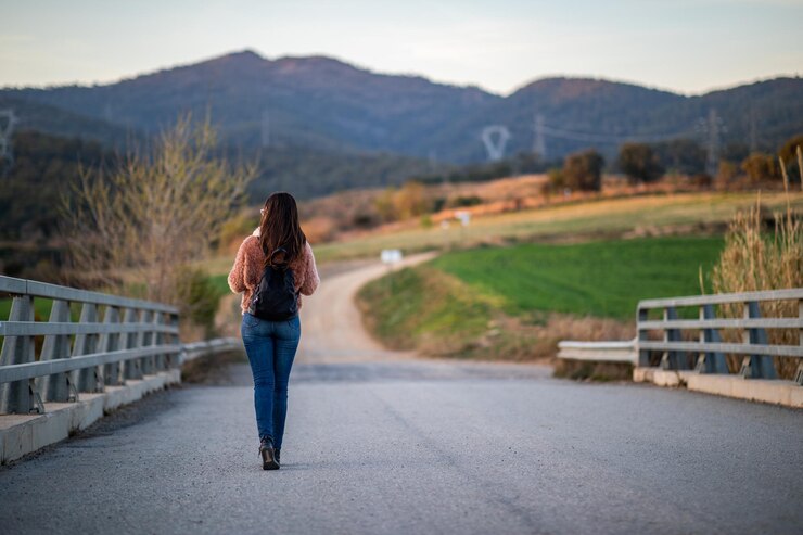 Foto vista traseira de uma mulher de pé na montanha contra o céu
