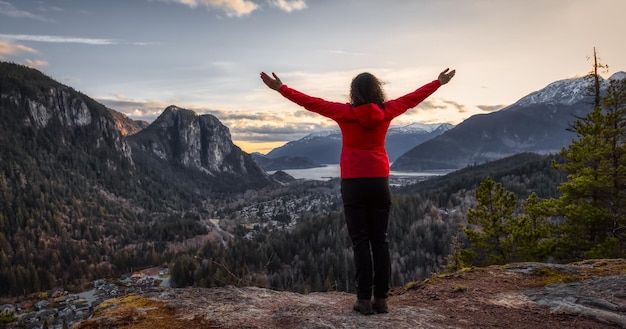 Foto vista traseira de uma mulher de pé na montanha contra o céu