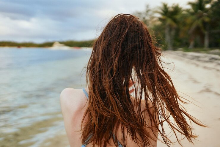 Foto vista traseira de uma mulher de pé na praia