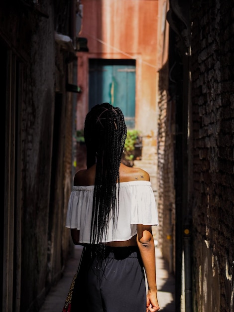 Vista traseira de uma mulher de pé no beco