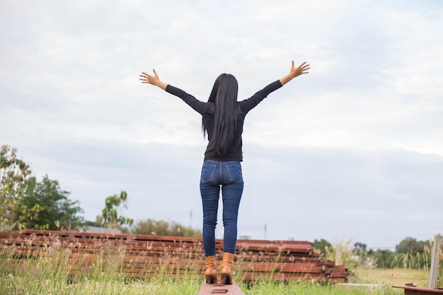 Foto vista traseira de uma mulher de pé no campo contra o céu