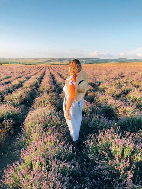 Foto vista traseira de uma mulher de pé no campo contra o céu