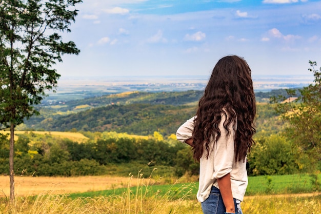 Foto vista traseira de uma mulher de pé no campo