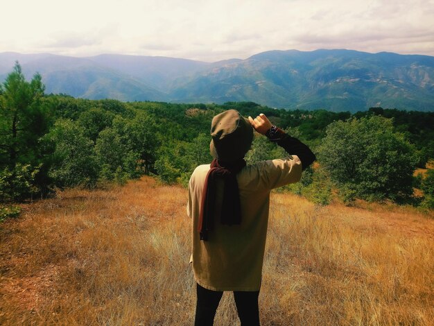 Foto vista traseira de uma mulher de pé no campo