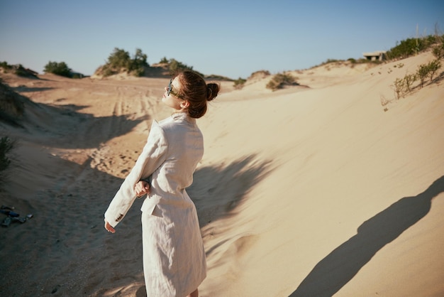 Foto vista traseira de uma mulher de pé no deserto