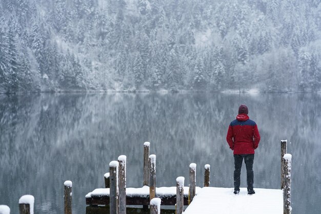 Foto vista traseira de uma mulher de pé no lago contra a montanha