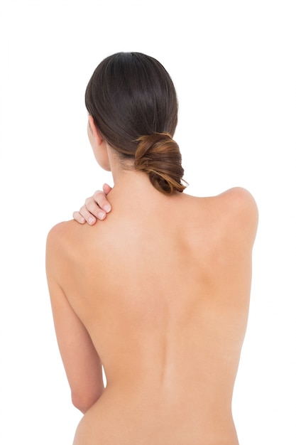 Vista traseira de uma mulher em forma de topless com dor no ombro