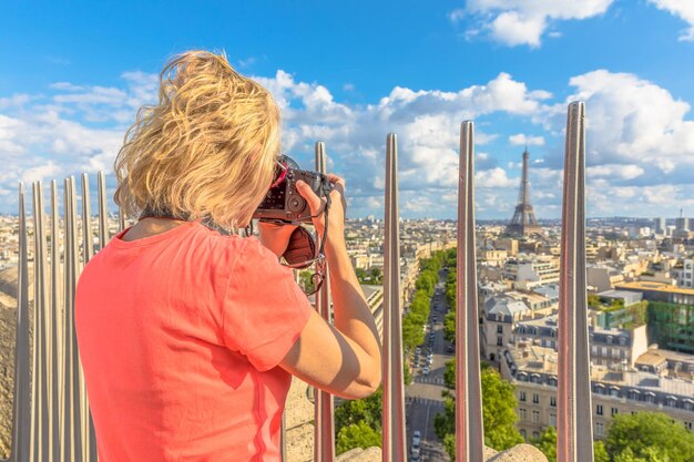 Foto vista traseira de uma mulher fotografando um edifício histórico