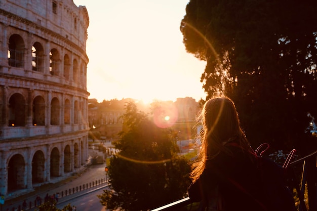 Foto vista traseira de uma mulher na cidade ao pôr-do-sol