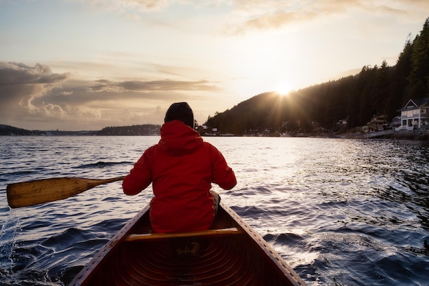 Foto vista traseira de uma mulher no mar contra o céu durante o pôr-do-sol