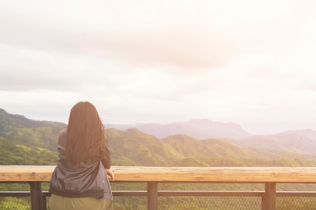 Vista traseira de uma mulher olhando para as montanhas