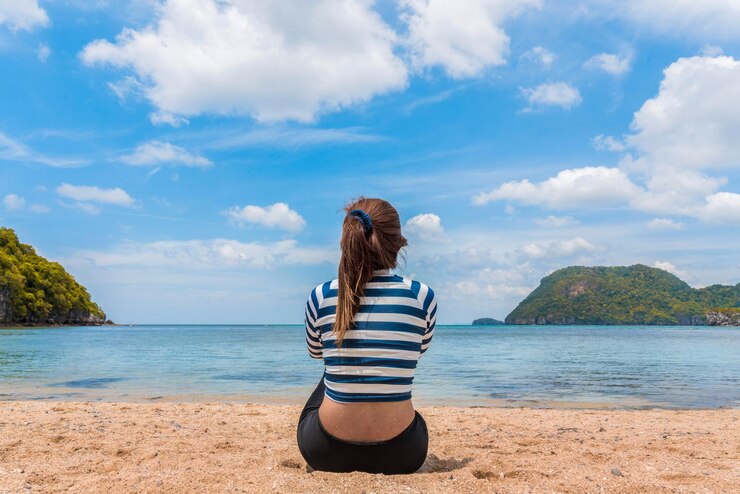 Foto vista traseira de uma mulher olhando para o mar contra o céu