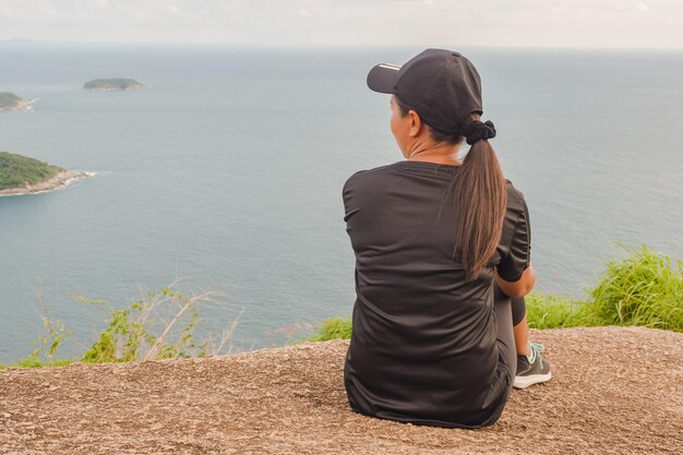 Vista traseira de uma mulher olhando para o mar