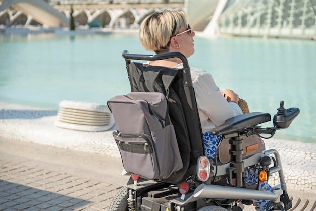 Vista traseira de uma mulher pensativa na cadeira de rodas