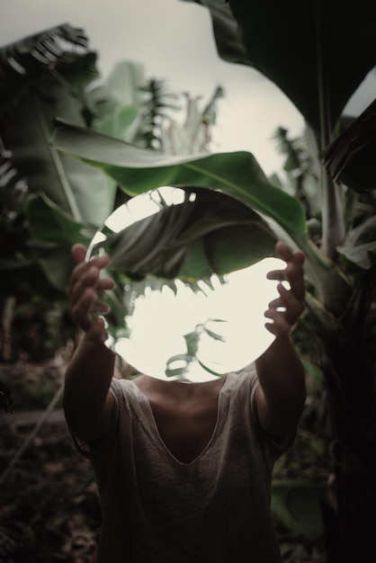 Foto vista traseira de uma mulher segurando uma planta