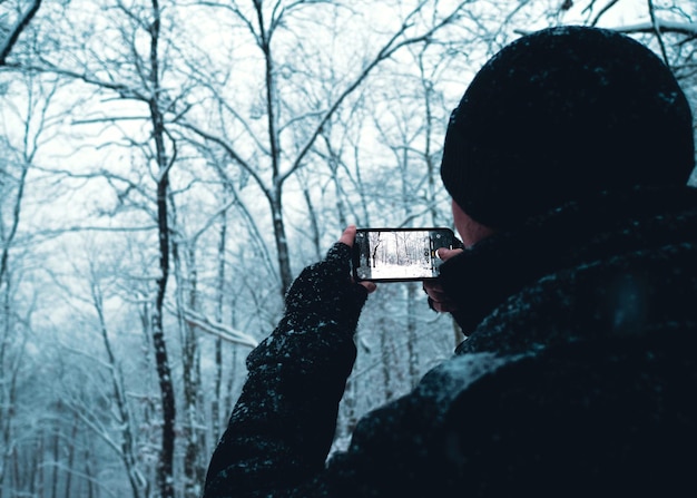 Foto vista traseira de uma pessoa a fotografar através de um telemóvel