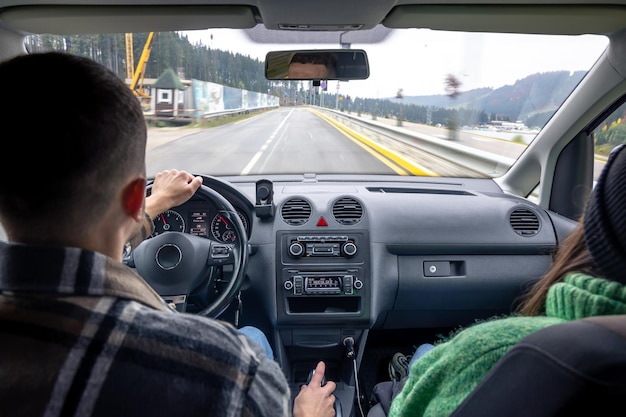 Vista traseira do banco do passageiro do homem e da senhora sentados dentro do carro