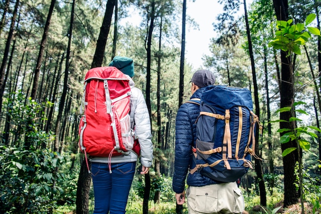 Vista traseira do casal de mochileiros asiáticos viajando juntos