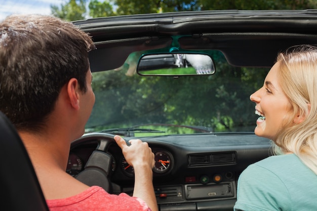 Foto vista traseira do casal sorridente no cabriolet