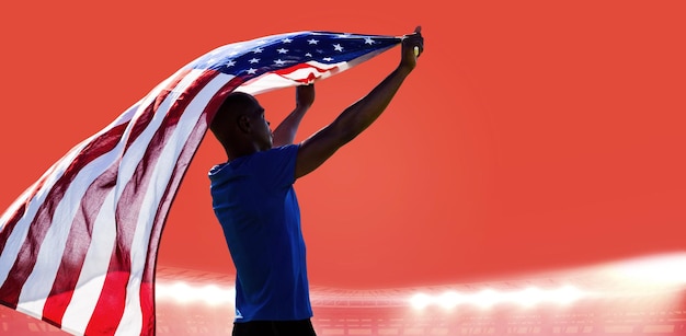 Vista traseira do desportista levantando uma bandeira americana