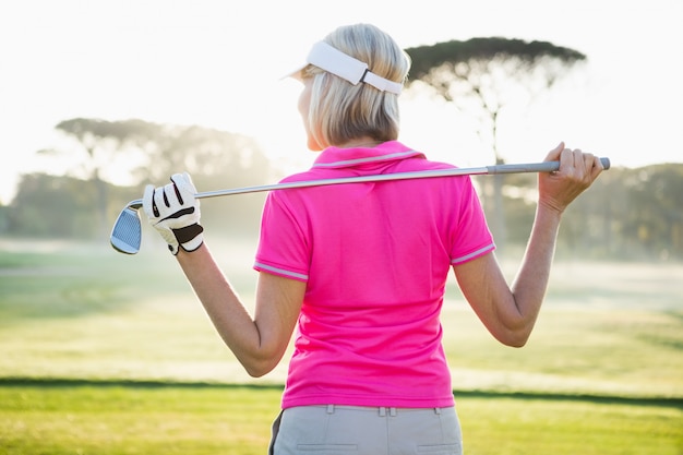 Vista traseira do golfista mulher segurando seu clube