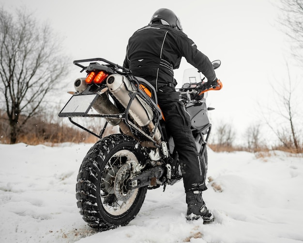 Vista traseira do homem andando de moto no dia de inverno