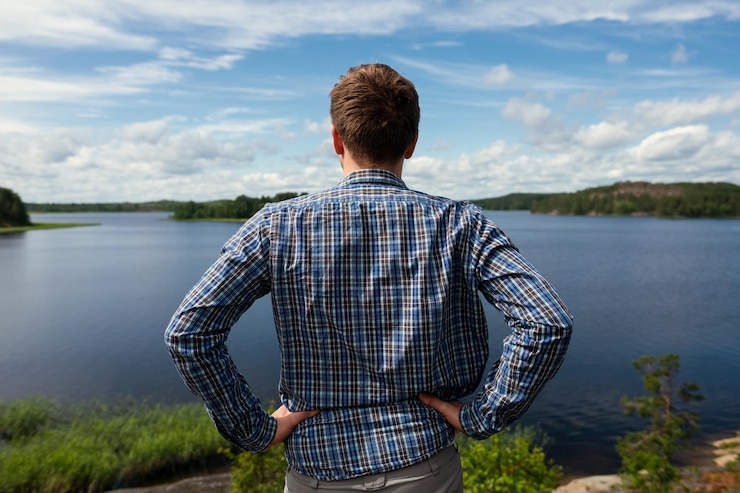 Foto vista traseira do homem olhando o lago descansando durante o trekking