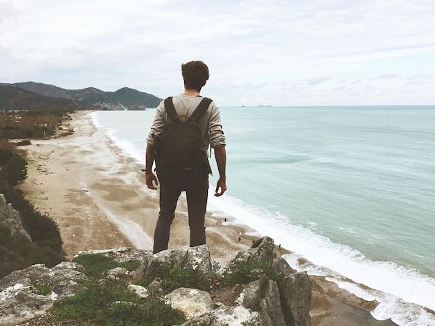 Foto vista traseira do homem olhando para o mar