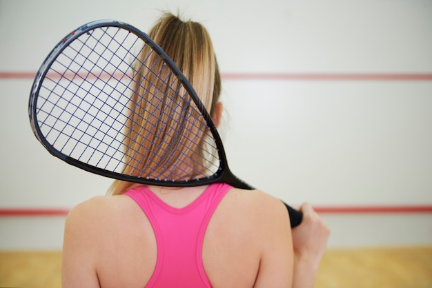 Vista traseira do jogador de squash ou tênis com raquete