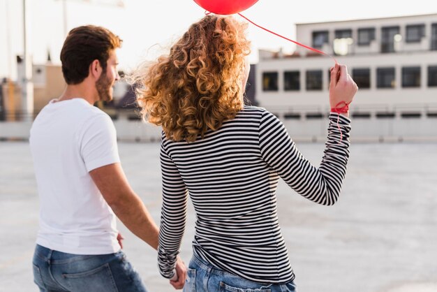 Foto vista traseira do jovem casal ao pôr do sol