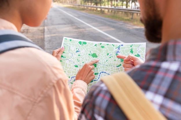 Foto vista traseira do jovem casal verificando um novo destino no mapa