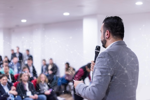 vista traseira do jovem empresário de sucesso na sala de conferências de negócios com apresentações públicas. Audiência na sala de conferências. clube de empreendedorismo