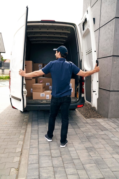 Foto vista traseira do mensageiro fechando a porta do caminhão de entrega