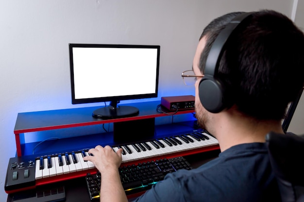 Vista traseira do produtor musical trabalhando remotamente em seu estúdio de música em casa