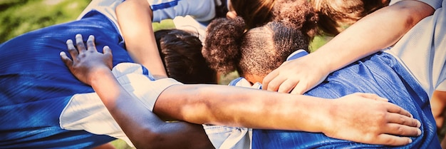 Foto vista traseira do time de futebol se amontoando