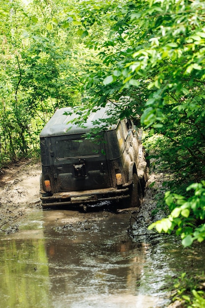 Foto vista traseira do veículo utilitário offroad russo verde uaz hunter quebrou encravado na estrada suja na floresta entre árvores