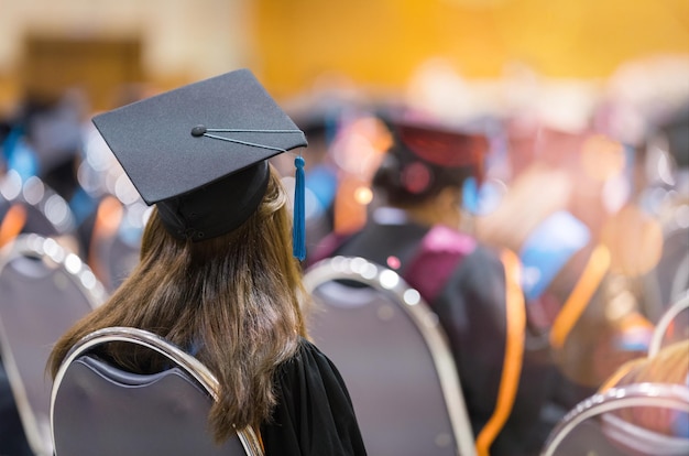 Foto vista traseira dos graduados universitários em vestidos de formatura e bonés