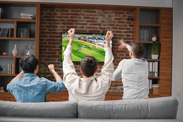 Pessoas assistindo futebol na tv