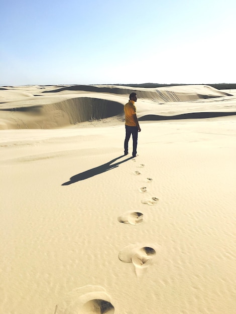 Foto vista traseira em comprimento de um homem de pé no deserto